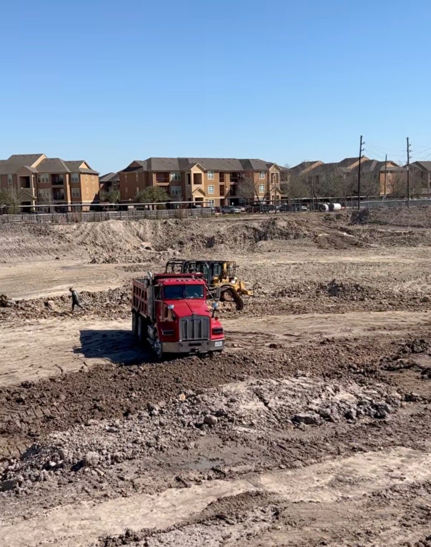 Supreme Logistics dump truck working a graded residential development site in Greater Houston, TX